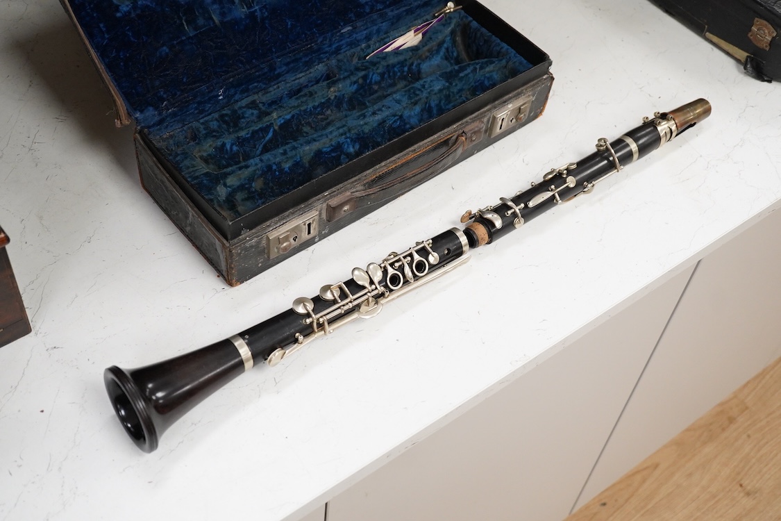 An early 20th century wooden Boosey and Hawkes clarinet in a fitted leather case